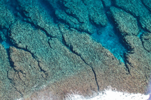 Vol en parapente au-dessus du lagon turquoise de La Réunion, avec vue panoramique sur l’océan Indien.
