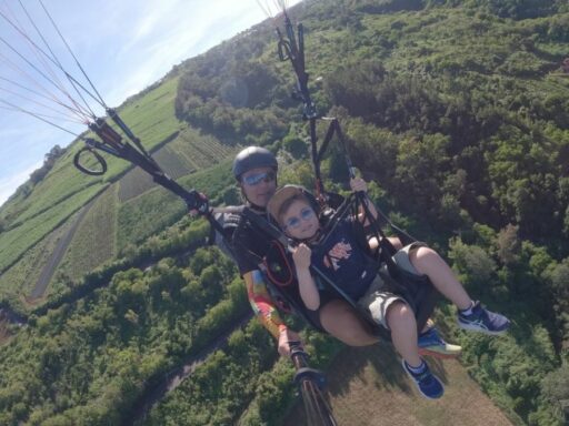 Enfant en parapente survolant une forêt luxuriante à La Réunion, une première expérience magique et en douceur