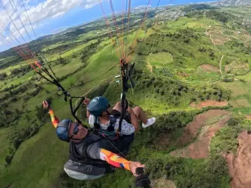 Vol en parapente au-dessus de la forêt des hauts à La Réunion, une expérience aérienne unique.
